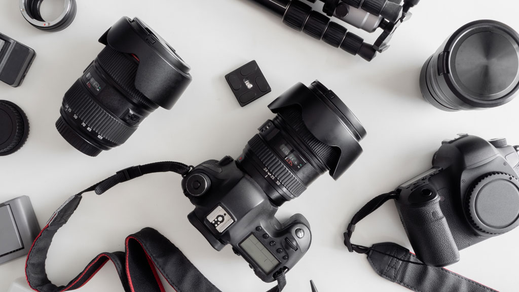 Deux professionnels audiovisuels comparant différentes caméras sur table de préparation